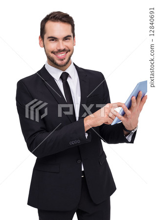 Businessman using his tablet while looking at the camera 12840691