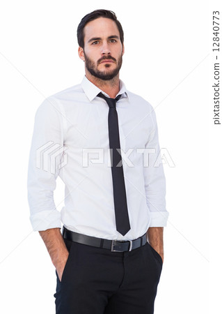 Unsmiling businessman standing with hands in pockets 12840773