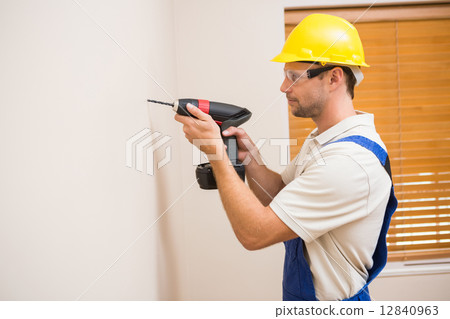 Construction worker drilling hole in wall Construction worker drilling hole in wall 12840963