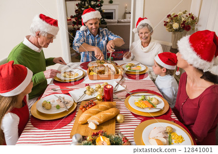 Father in santa hat carving roast turkey at christmas Father in santa hat carving roast turkey at christmas 12841001