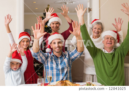 Happy extended family in santa hat cheering at camera 12841025