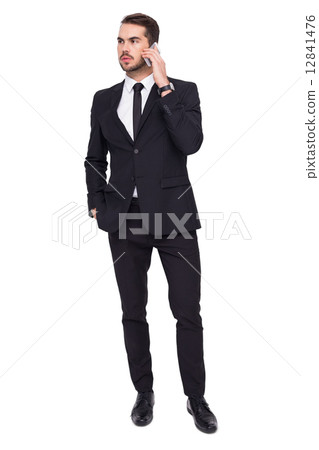 Serious businessman hand in pocket phoning Serious businessman hand in pocket phoning 12841476