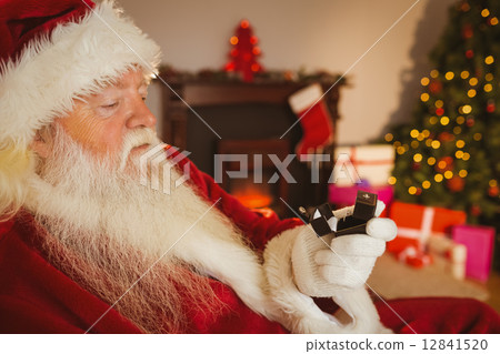 Santa claus holding engagement ring with his box 12841520