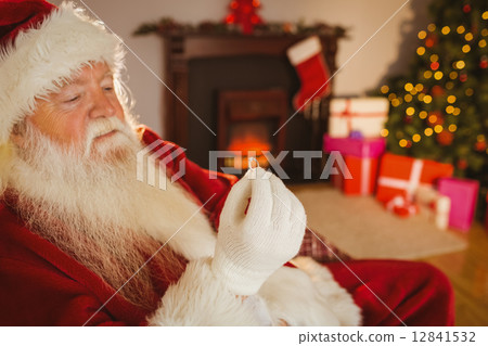 Santa claus holding engagement ring Santa claus holding engagement ring 12841532