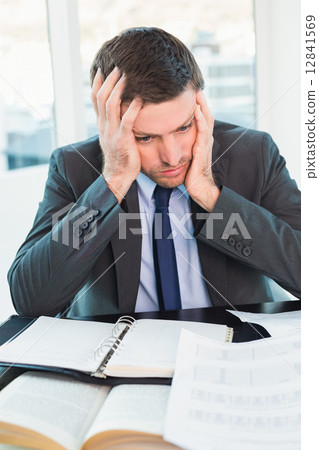 Stock Photo: Stressed businessman with head in hands