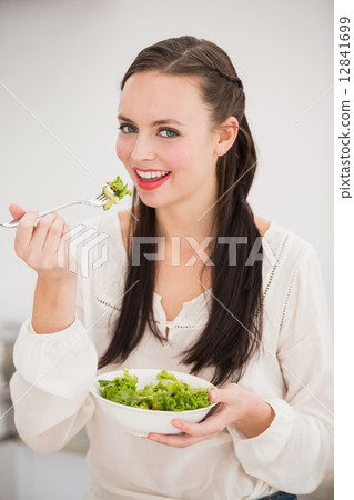 Pretty brunette preparing a healthy salad 12841699