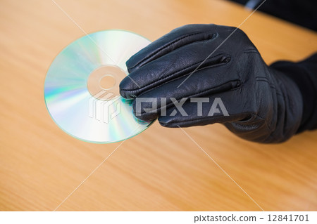 Hacker holding a cd rom Hacker holding a cd rom 12841701