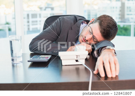 Exhausted businessman sleeping at his desk 12841807