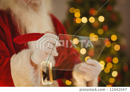 Santa claus writing list on the glass 12842047