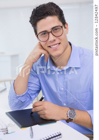 Casual graphic designer working at his desk Casual graphic designer working at his desk 12842497