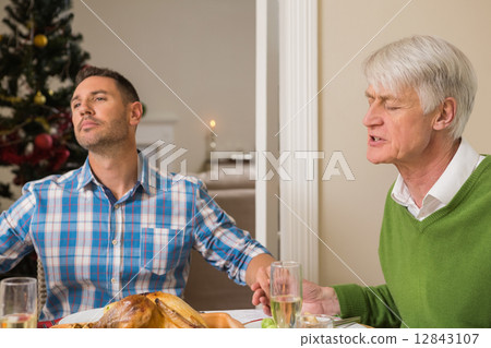 Extended family saying grace before christmas dinner Extended family saying grace before christmas dinner 12843107