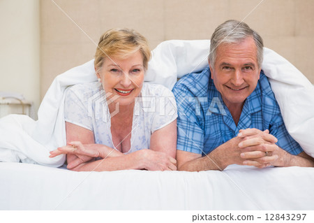 Senior couple smiling under the duvet Senior couple smiling under the duvet 12843297