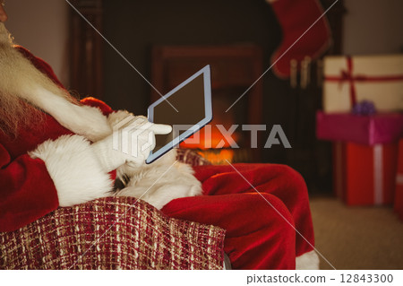 Mid section of santa touching tablet Mid section of santa touching tablet 12843300