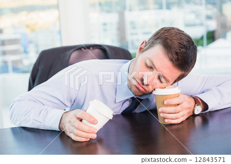 Exhausted businessman sleeping at his desk 12843571