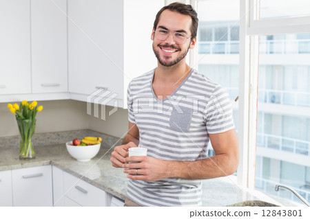 Young man smiling and holding coffee 12843801