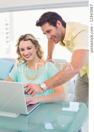 Casual business team working together with laptop Casual business team working together with laptop 12843867