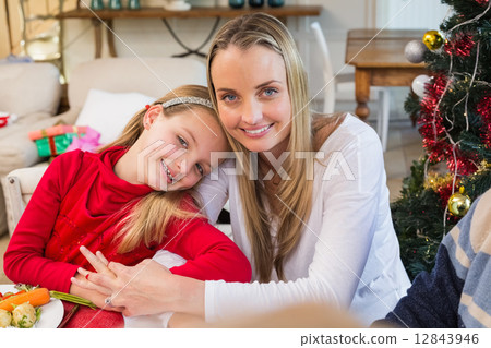 Festive mother and daughter smiling at camera Festive mother and daughter smiling at camera 12843946