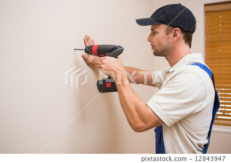Construction worker drilling hole in wall Construction worker drilling hole in wall 12843947