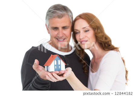 Casual couple holding small house Casual couple holding small house 12844182