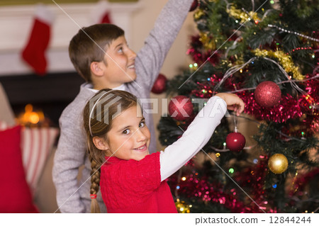Brother and sister decorating the christmas tree together 12844244