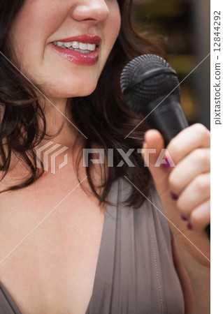 Close up of beautiful woman singing into a microphone Close up of beautiful woman singing into a microphone 12844292