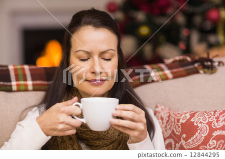 Pretty brunette enjoying hot chocolate 12844295