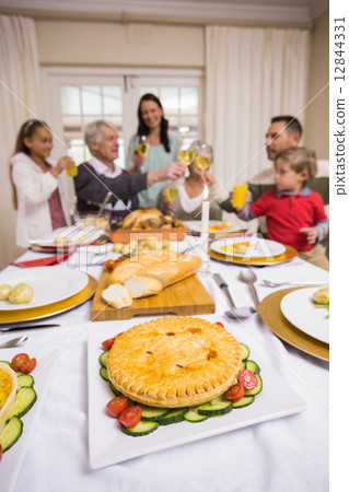Smiling family toasting at christmas dinner Smiling family toasting at christmas dinner 12844331