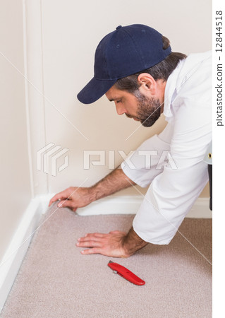 Handyman laying down a carpet Handyman laying down a carpet 12844518