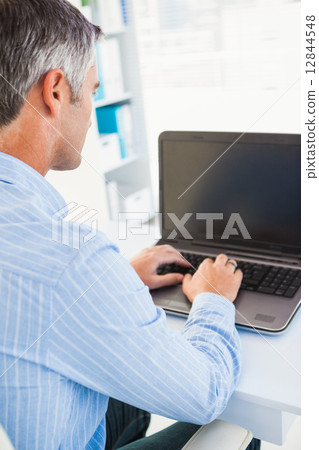 Focused man using his laptop Focused man using his laptop 12844548