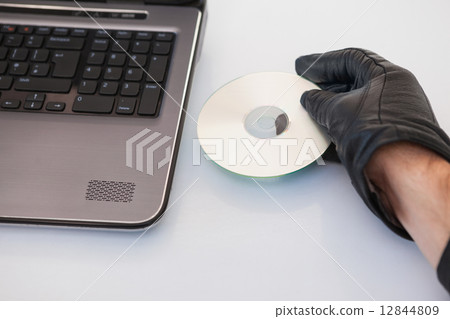 Burglar hacking and putting a cd-rom in laptop Burglar hacking and putting a cd-rom in laptop 12844809