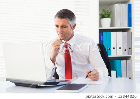 Businessman holding his glasses and take notes Businessman holding his glasses and take notes 12844826