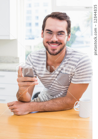 Young man using smartphone while having coffee 12844835