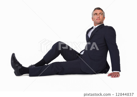 Smiling businessman sitting on the floor Smiling businessman sitting on the floor 12844837