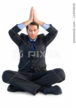 Calm businessman sitting in lotus pose with hands together 12844849