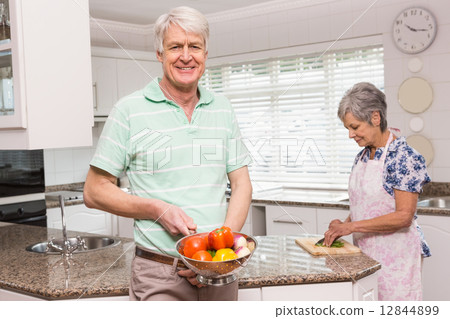 Senior man showing colander of vegetables 12844899