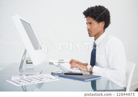 Focused businessman typing on keyboard Focused businessman typing on keyboard 12844973