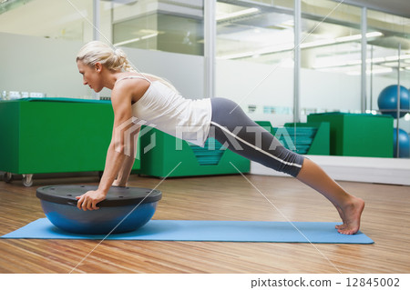 Woman doing fitness exercise in fitness studio 12845002