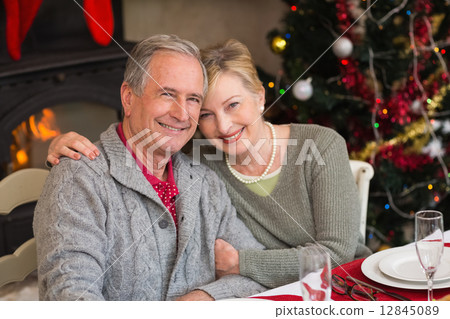 Portrait of smiling mature couple at table 12845089