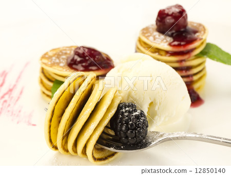 sweet miniature pancakes with blackberry jam in the restaurant 12850140