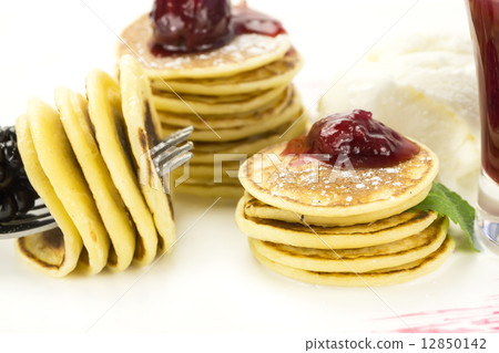 sweet miniature pancakes with blackberry jam in the restaurant 12850142