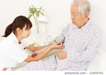 Nurse measuring blood pressure and old man 12856701