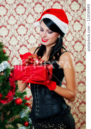 Beautiful girl near a christmas tree with gifts in hand 12856949