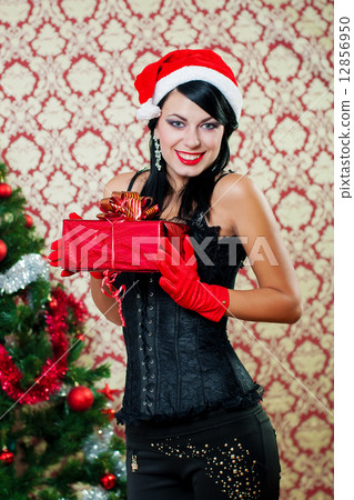 Beautiful girl near a christmas tree with gifts in hand 12856950
