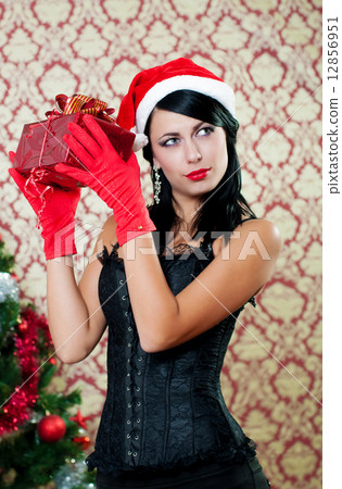 Beautiful girl near a christmas tree with gifts in hand 12856951