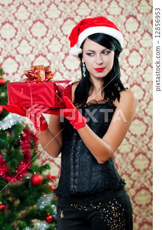 Beautiful girl near a christmas tree with gifts in hand 12856953