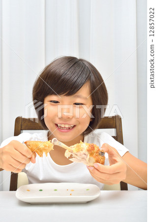 A girl who eats fried chicken deliciously A girl who eats fried chicken deliciously 12857022
