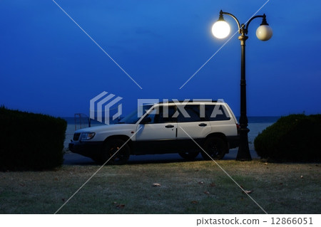 White Car on Coast Road under Lantern in Summer Night. 12866051
