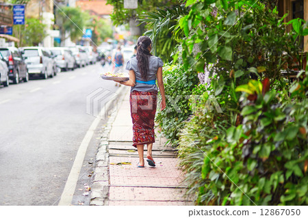 Balinese woman carrying offerings to gods Balinese woman carrying offerings to gods 12867050