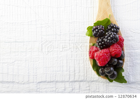 forest berries in wooden spoon on white wooden table forest berries in wooden spoon on white wooden table 12870634