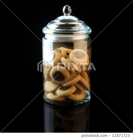 Glass jar full of chocolate cookies on black background 12871723